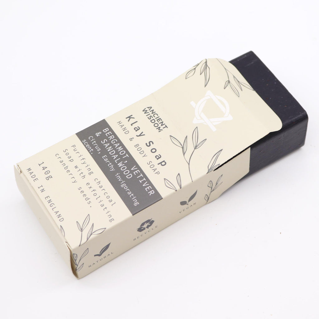 Klay Soap - Bergamot & Sandalwood. A rectangular bar of natural, dark-coloured soap with visible cranberry seeds for exfoliation. The soap is infused with Fuller's earth clay and activated charcoal for detoxifying properties.